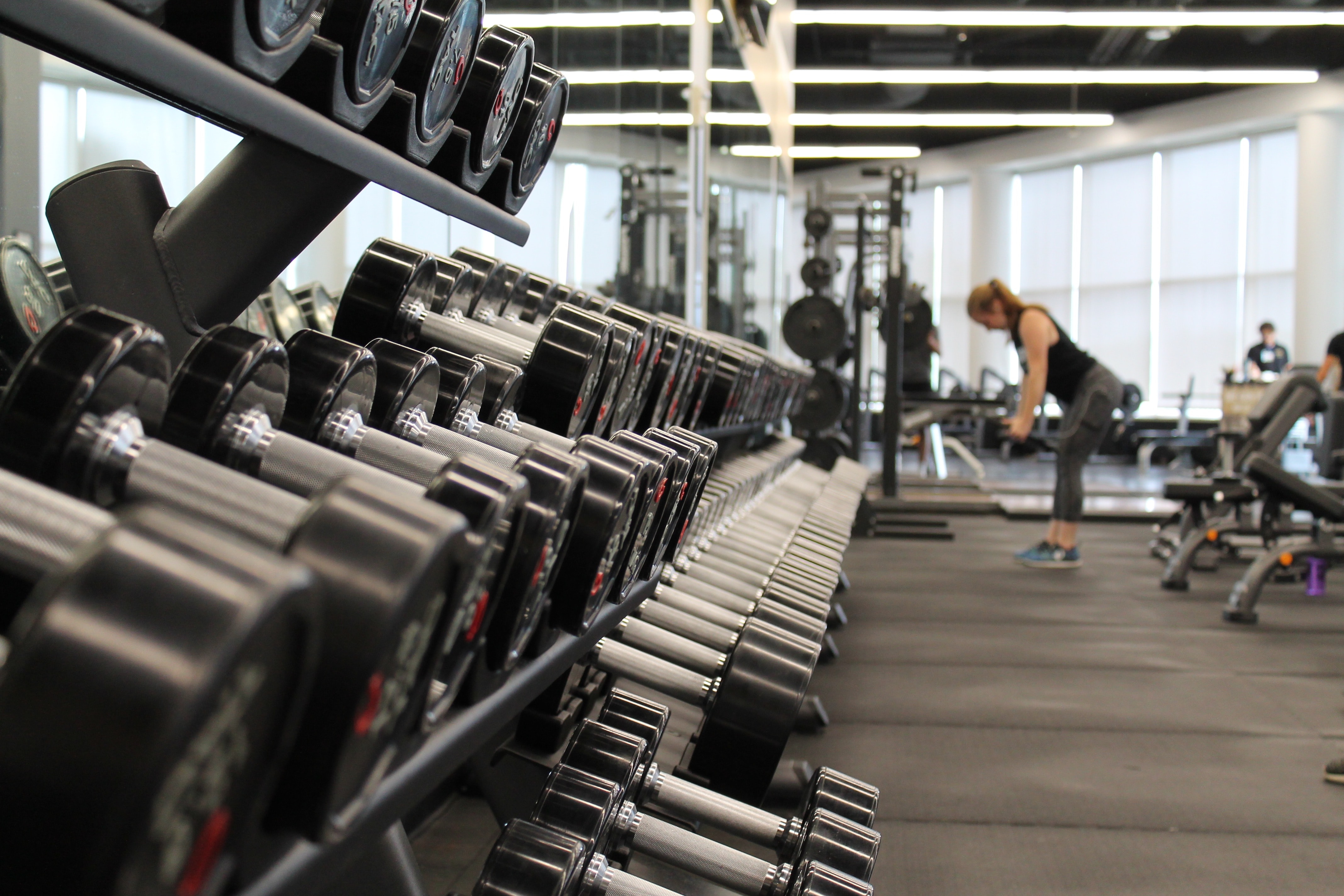 close up of dumbell rack, gym in background